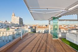 Auvent Cofre Light sur une terrasse sur le toit avec vue sur Madrid